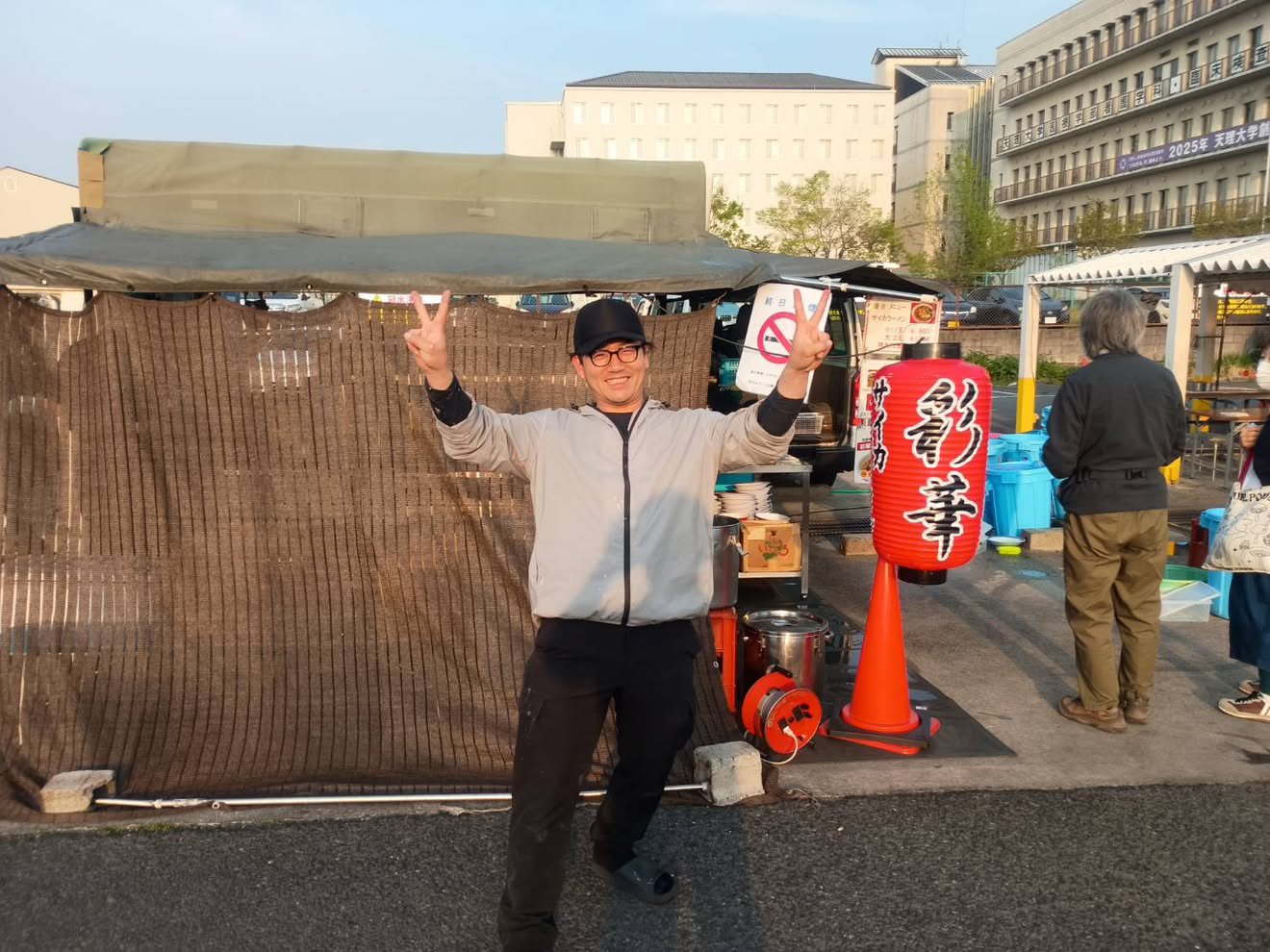 屋台の前でピース